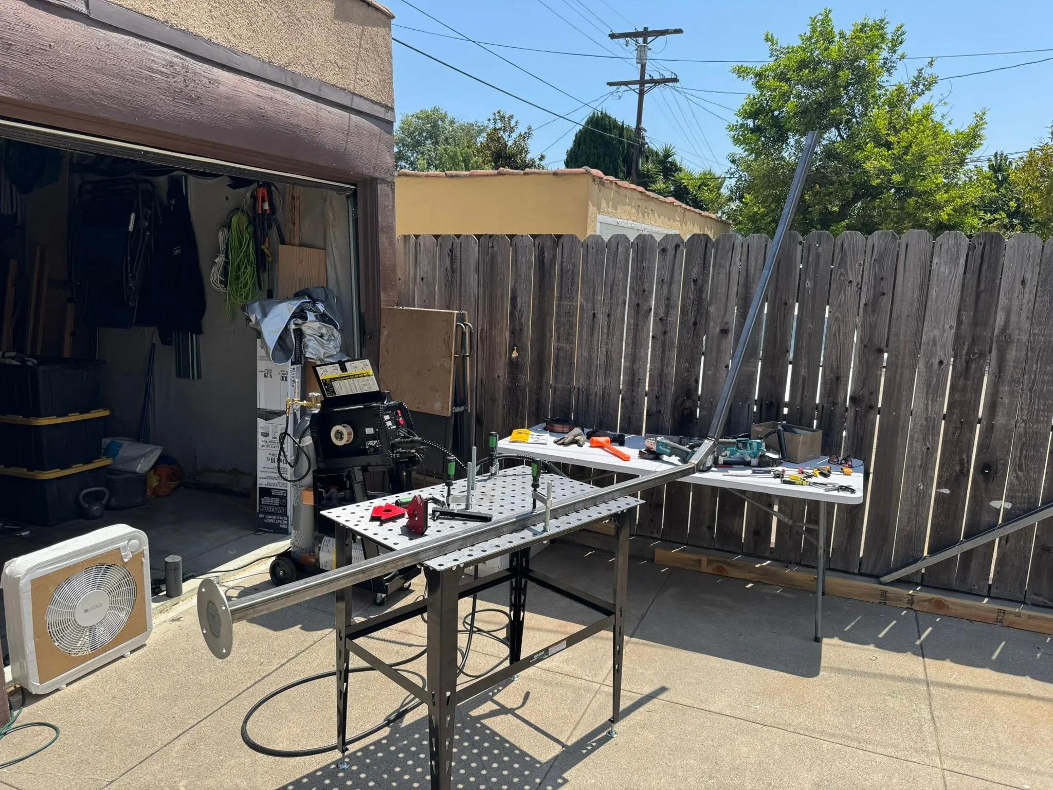 A backyard welding setup with a fixture table and tools