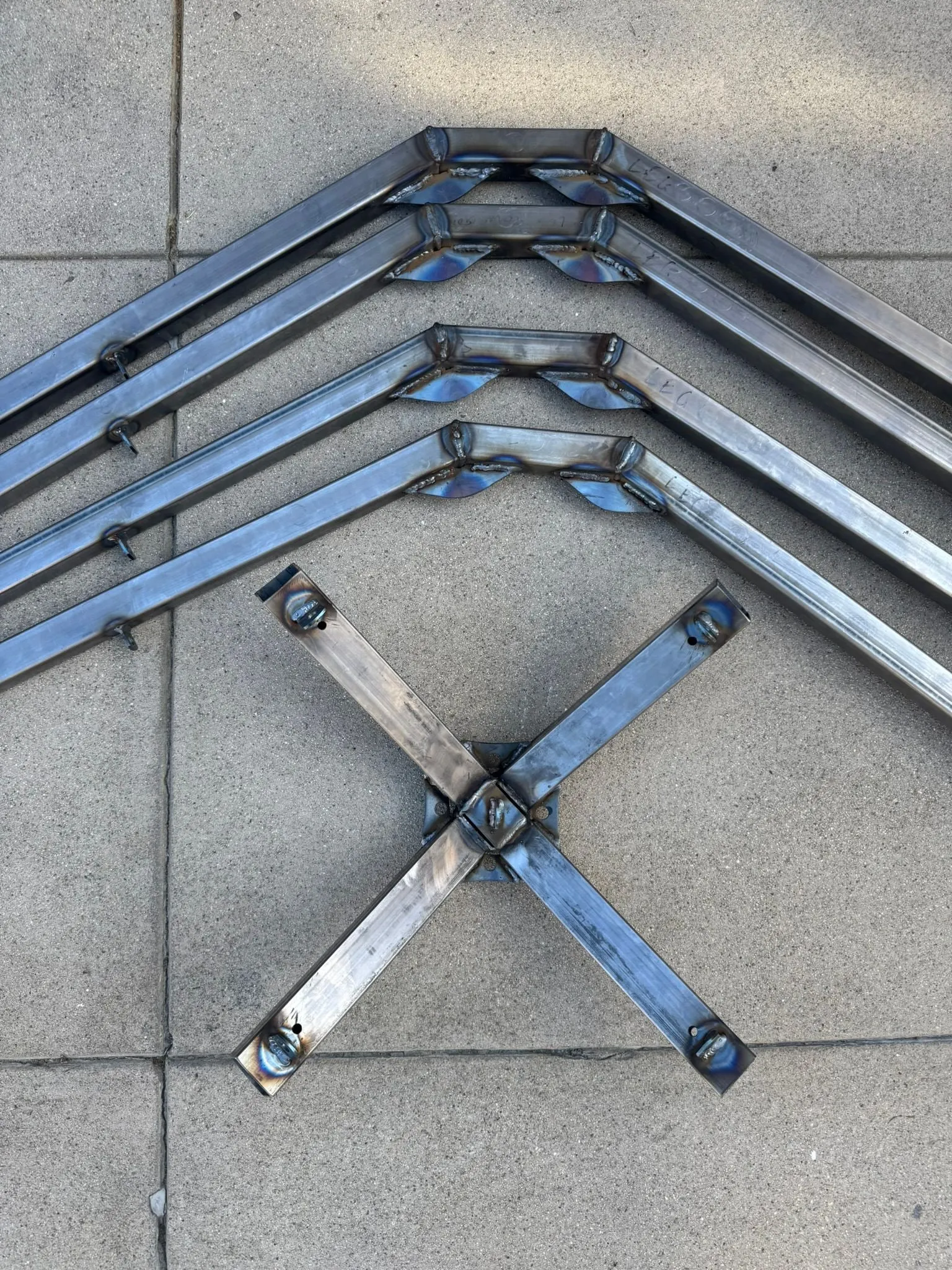 The welded crown with the four legs sleeved in, lying on concrete