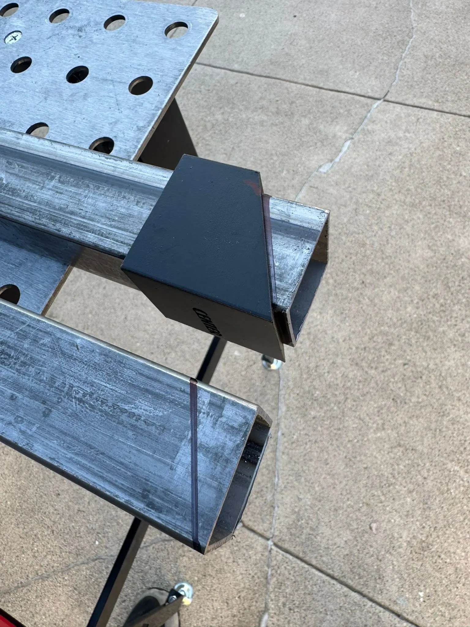 A black printed layout sleeve slid over square steel tube