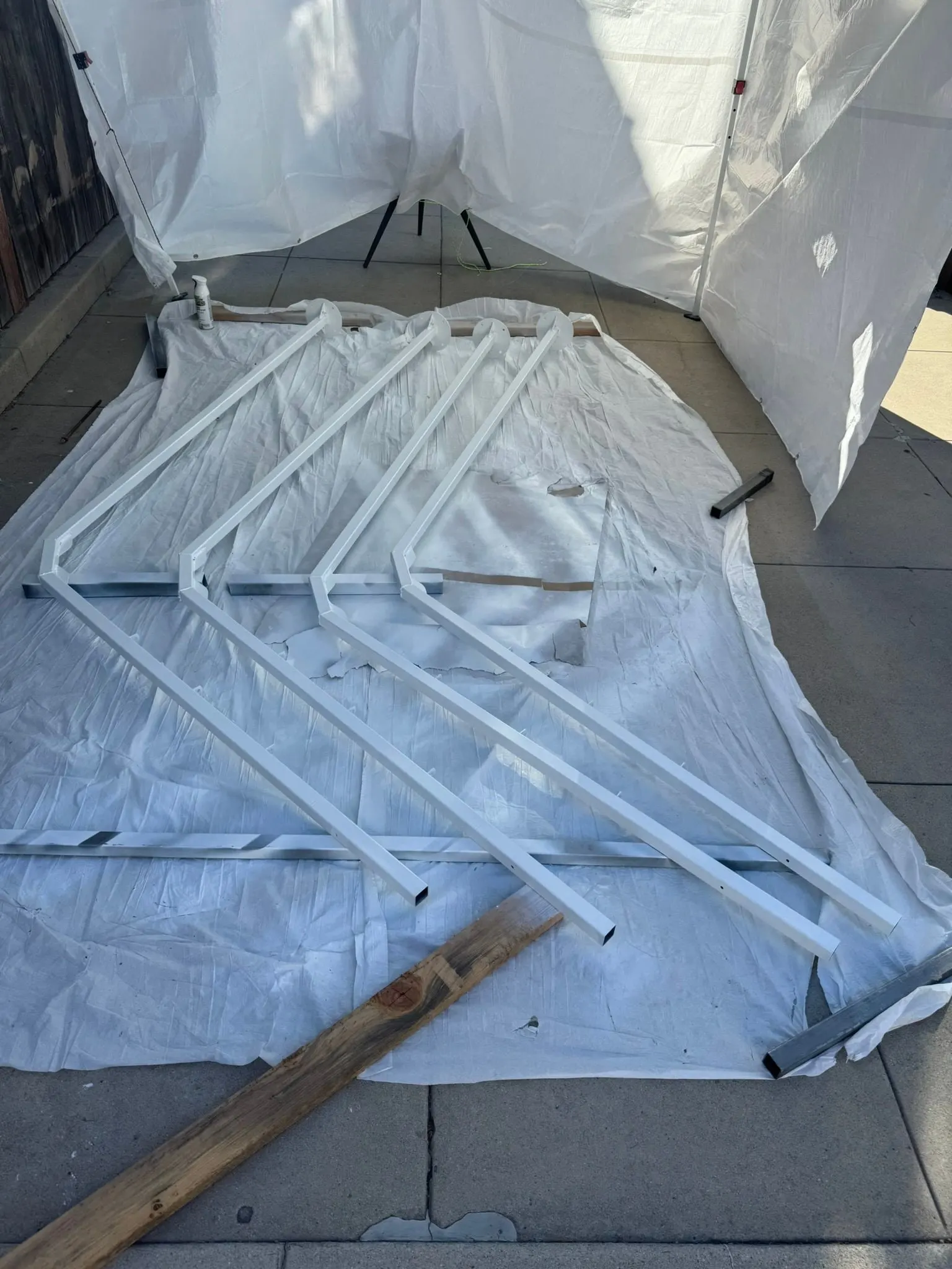 Legs painted gloss white, drying on a tarp