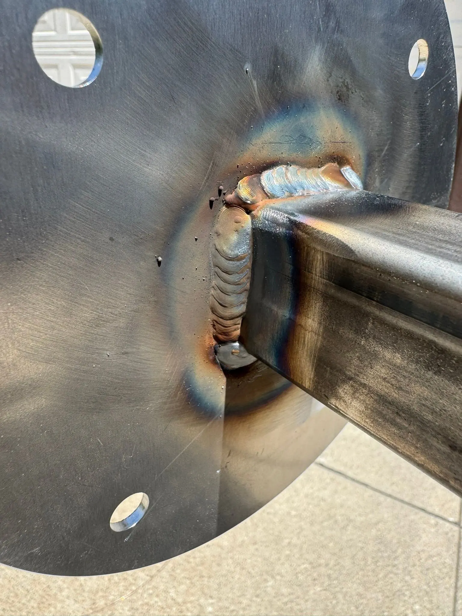 Close-up of a corner weld where a tube meets a foot plate