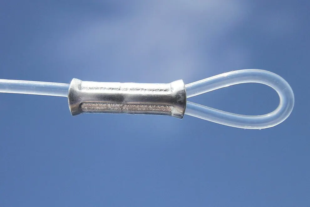 A loop of clear monofilament closed with an aluminum crimp sleeve, against blue sky